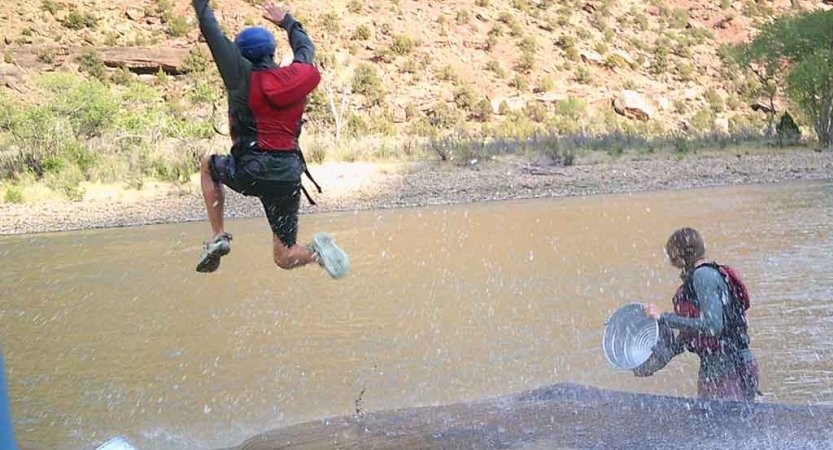A person is mid-jump into a body of water.